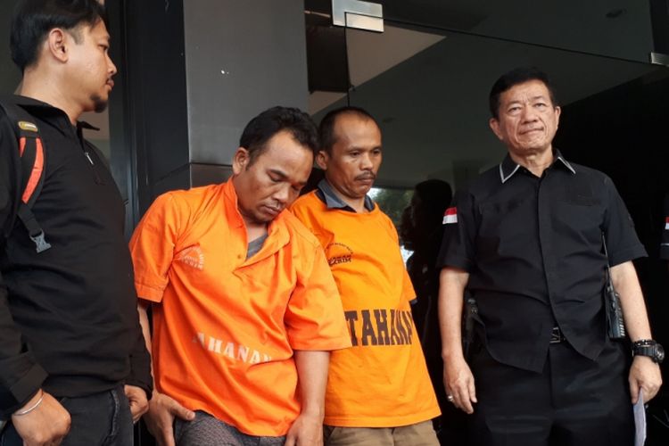 Frenki Manik (34) dan Perdi Pakpahan (43) mengenakan baju tahanan warna oranye setelah di tangkap polisi  di Bekasi, Selasa (10/7/2018). Mereka ditangkao karena membobol minimarket Indomart