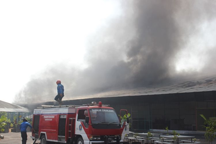 Petugas damkar berupaya memadamkan api yang membakar gudang penyimpanan surpet di kawasan pergudangan Rawabango, Cianjur, Jawa Barat, Selasa (26/04/2019)