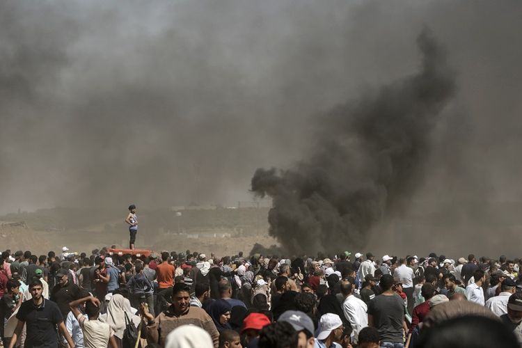 Demonstran Palestina terlibat dalam bentrokan dengan otoritas Israel di perbatasan Jalur Gaza Senin (14/5/2018). Bentrokan terjadi beberapa jam sebelum peresmian Kedutaan Besar Amerika Serikat di Yerusalem.