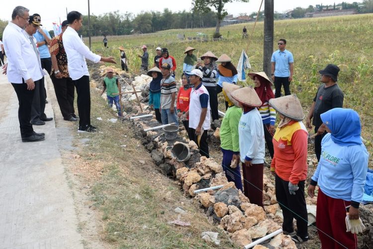 Presiden Joko Widodo (Jokowi) didampingi Menteri Desa, Pembangunan Daerah Tertinggal, dan Transmigrasi (Mendes PDTT) Eko Putro Sandjojo meninjau program Padat Karya Tunai (PKT) pembangunan talud jalan di Desa Tambirejo, Kecamatan Toroh, Kabupaten Grobogan, Jawa Tengah, Sabtu (15/9/2018)