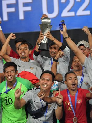 Pelatih Timnas U-22 Indra Sjafri (tengah belakang) mengangkat Piala AFF U-22 seusai penganugerahan piala di Stadion Nasional Olimpiade Phnom Penh, Kamboja, Selasa (26/2/2019). Indonesia menjadi juara setelah mengalahkan Thailand di babak final dengan skor 2-1.