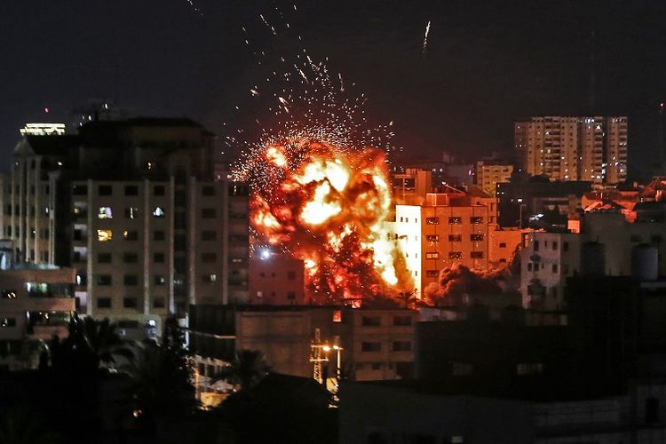 Ledakan terlihat di antara bangunan selama serangan udara Israel di Kota Gaza pada Sabtu (4/5/2019). (AFP/Mahmud Hams)
