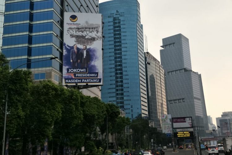 Reklame bergambar Presiden Joko Widodo dan Ketua Umum Partai Nasdem Surya Paloh dipasang di Jalan Gatot Subroto, Jakarta Selatan, Jumat (13/7/2018).