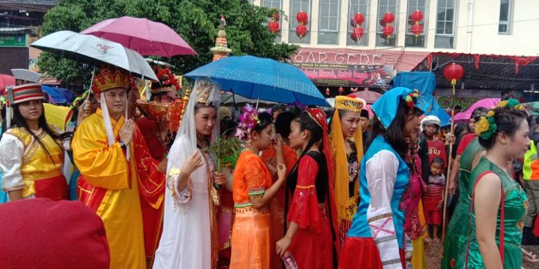 Peserta tetap berjalan mengikuti kirab budaya Grebeg Sudiro 2019 di Solo, Minggu (3/2/2019), meski diguyur hujan cukup lebat.