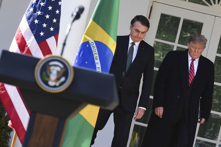 Presiden AS Donald Trump (kanan) berjalan bersama Presiden Brasil Jair Bolsonaro menuju tempat konferensi pers usai menggelar pertemuan di Gedung Putih, Selasa (19/3/2019).
