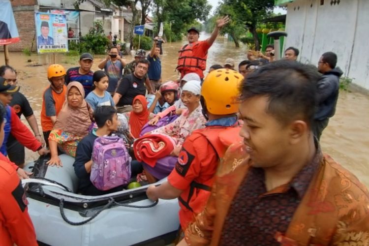 EVAKUASI-Tim Sar gabungan mengevakuasi siswa (berhelm) dan warga yang terdampak banjir di Desa Jerukgulung, Kecamatan Balerejo, Kabupaten Madiun, Jawa Timur, Rabu ( 6 / 3 / 2019) sore. Hingga malam ini bencana banjir makin meluas hingga delapan kecamatan di Kabupaten Madiun.