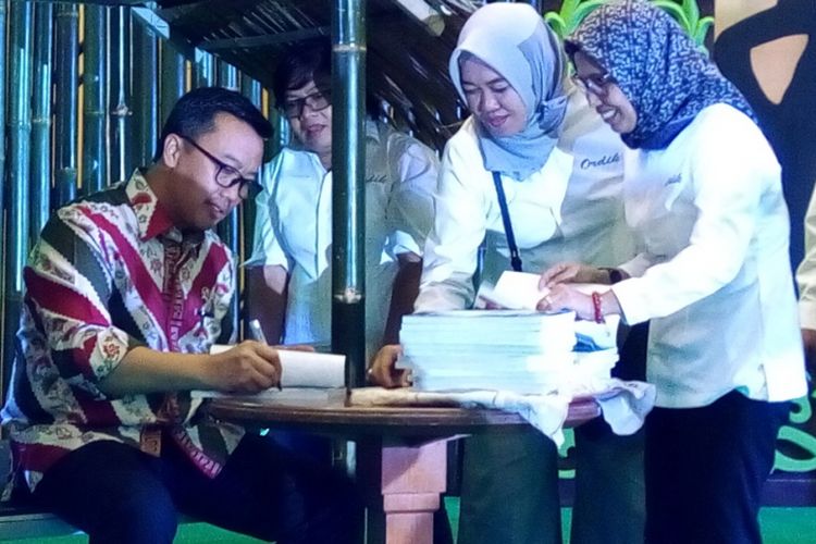 Menteri Pemuda dan Olahraga Imam Nahrawi (duduk berkemeja batik) menandatangani buku Olahraga Desa Menuju Dunia-Lebihi Ekspektasi Di Gelaran Perdana pada Selasa (7/8/2018) di Jakarta. Buku setebal iv + 188 halaman berisi laporan kegiatan Gala Desa 2017.