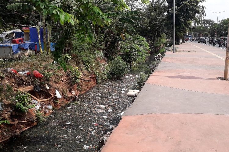 Sampah daun dan kemasan makanan menumpuk di saluran air Jalan I Gusti Ngurah Rai, Durem Sawit, Jakarta Timur pada Minggu (24/6/2018).