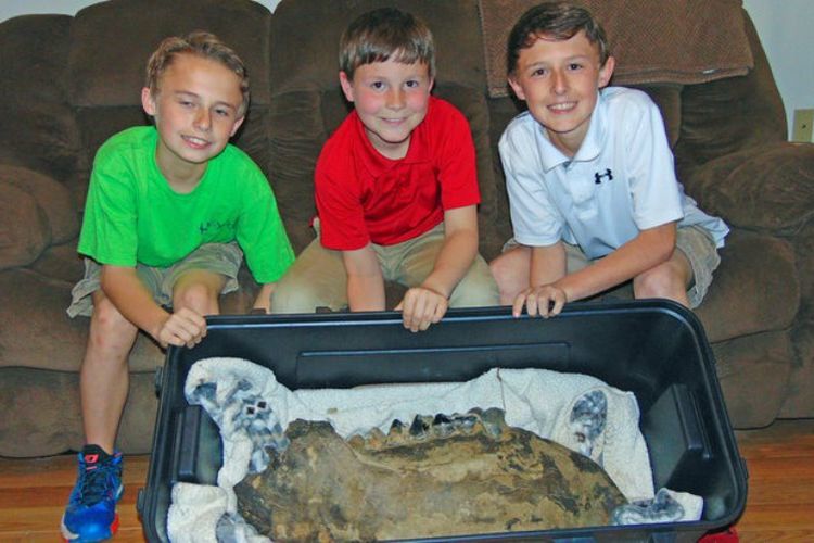 (ki-ka) Shawn Sellers, Michael Mahalitc, dan Caid Sellers, memamerka tulang rahang kiri bawah mastodon yang mereka temukan di kawasan Bovina, Mississippi. 