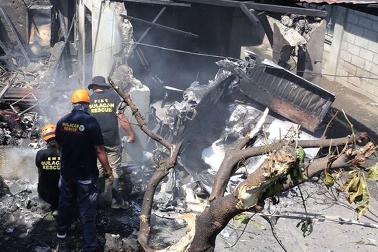 Petugas memeriksa lokasi jatuhnya pesawat yang menimpa rumah di Filipina, Sabtu (17/3/2018).