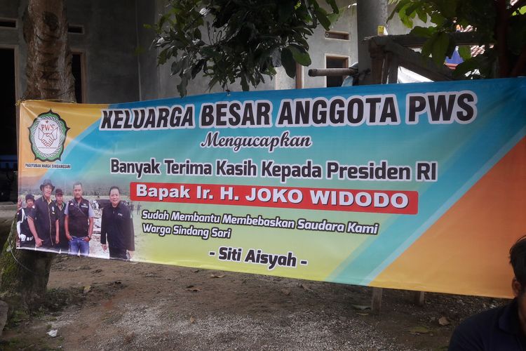 Spanduk ucapan terimakasih kepada Presiden Joko Widodo dipasang di Kampung Rancasumur, Desa Sindangsari, Kabupaten Serang, Banten untuk menyambut kepulangan Siti Aisyah