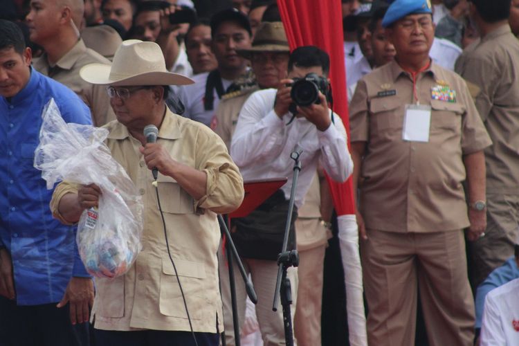Calon Presiden nomor urut 02 Prabowo Subianto menunjukkan kantong plastik berisi uang saat menghadiri kampanye di pelataran Benteng Kuto Besak (BKB) Palembang, Sumatera Selatan, Selasa (9/4/2019).