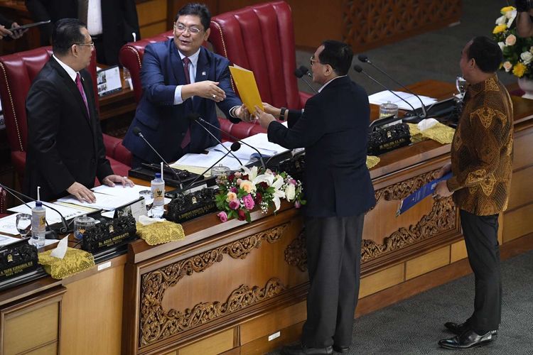 Pimpinan Dewan Perwakilan Rakyat (DPR), Utut Adiyanto (kedua kiri) dan Bambang Soesatyo (kiri) menerima tanggapan tertulis dari fraksi-fraksi DPR saat Rapat Paripurna Masa Persidangan I Tahun Sidang 2019-2020 di Kompleks Parlemen Senayan, Jakarta, Kamis (5/9/2019). Rapat paripurna tersebut membahas RUU tentang Perubahan Atas UU Nomor 2 Tahun 2018 tentang perubahan kedua atas Undang-Undang No.17 Tahun 2014 tentang MPR, DPR dan DPRD (UU MD3), serta RUU tentang Perubahan Atas UU Komisi Pemberantasan Tindak Pidana Korupsi (KPK).