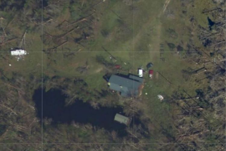 Foto satelit yang memperlihatkan pekarangan rumah keluarga yang terjebak usai diterjang badai Michael. Tampak huruf H-E-L-P yang merupakan sinyal permintaan bantuan.