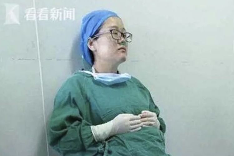 Dokter Yi Xianyou (42) terduduk setelah kelelahan akibat melakukan empat kali operasi selama hampir tujuh jam tanpa jeda.
