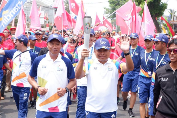 Dirut Telkomsel, Ririek Adriansyah berlari membawa obor api Asian Games 2018 menuju kantor Telkomsel di Bandar Lampung, Rabu (8/8/2018).