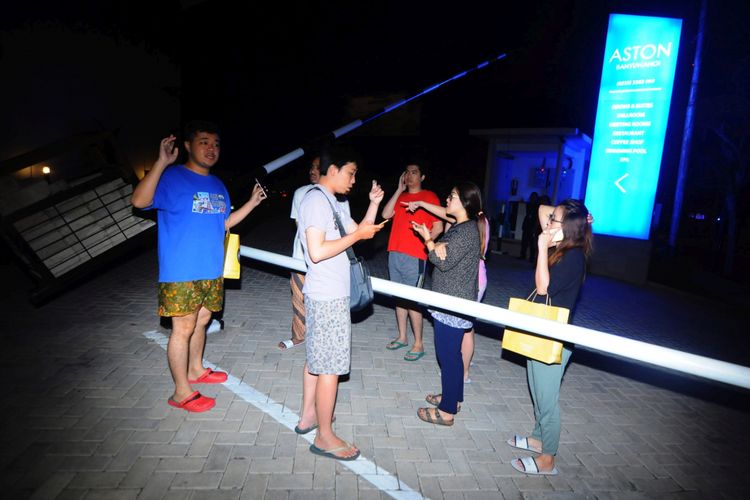 Sejumlah penghuni hotel berkumpul di luar gedung saat terjadi gempa di Banyuwangi, Jawa Timur, Kamis (11/10/2018). Berdasarkan data Badan Meteorologi, Klimatologi dan Geofisika (BMKG) terjadi gempa sebesar 6,4 skala richter yang terpusat di laut 61 Km Timur Laut Situbondo yang dirasakan juga di Banyuwangi.