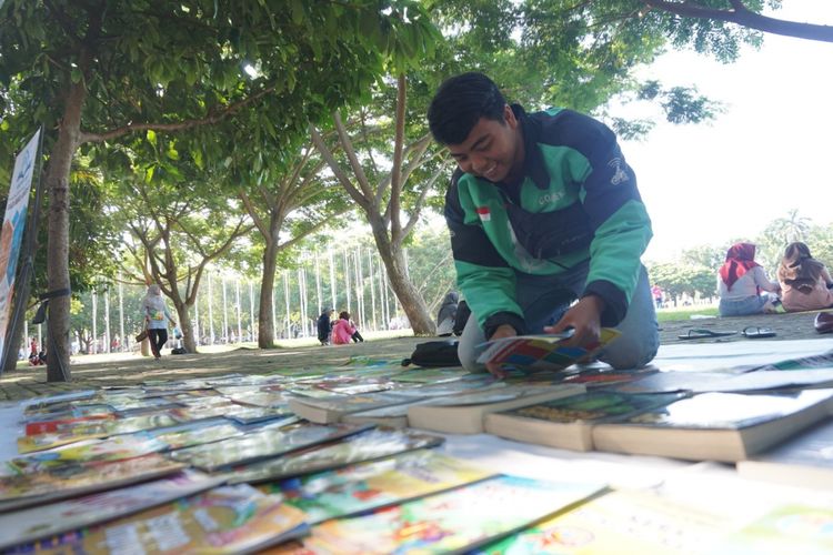 Agus Susanto, driver ojek online sedang membuka lapak buku gratis di Taman Blambangan setiap hari minggu pagi. Buku-buku tersebut disediakan secara gratis untuk dibaca bagi masyarakat yang sedang berolahraga di Taman Blambangan Banyuwangi
