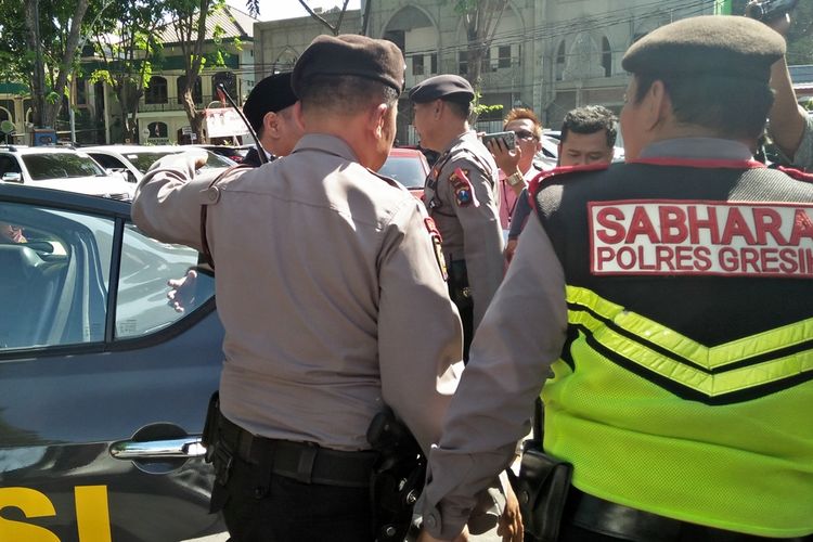 Mahmud (kiri, pakai kopiah) ketika baru saja turun dari mobil kepolisian yang mengantarnya menghadiri acara pelantikan sebagai anggota DPRD Gresik, Jumat (23/8/2019).