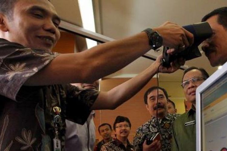 Petugas memindai iris mata Menteri Dalam Negeri Gamawan Fauzi untuk mencari data e-KTP miliknya di Kementerian Dalam Negeri, Jakarta Pusat, Kamis (8/11/2012). Mendagri menyatakan telah berhasil memenuhi target perekaman e-KTP dengan target 172.015.400 wajib KTP lebih cepat 55 hari daripada tenggat waktu yang ditentukan yaitu 31 Desember 2012.

