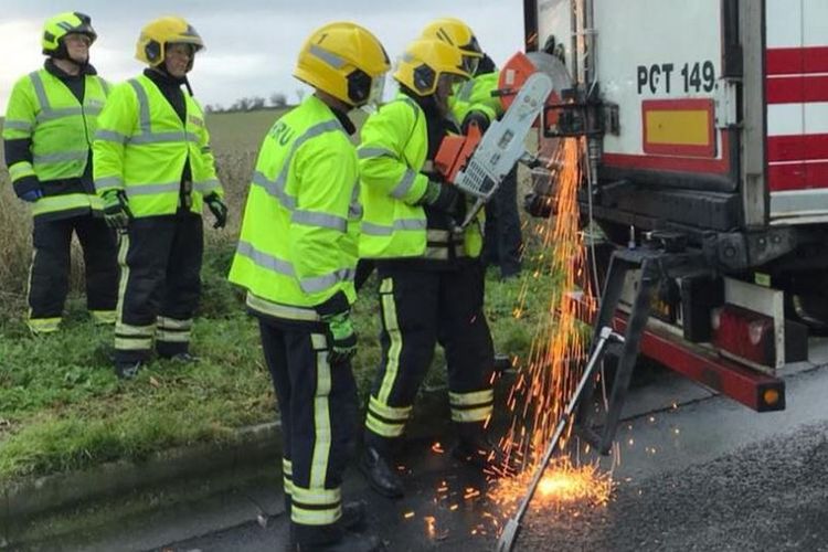 Petugas pemadam kebakaran membebaskan 11 imigran yang terjebak dalam truk berisi dagangan cokelat, di London, Inggris, Sabtu (2/12/2017). (Daily Mirror). 