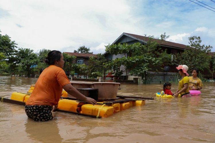 Penduduk menggunakan rakit darurat untuk melalui banjir di Hpa-an, negara bagian Karen, Myanmar, pada Senin (30/7/2018). (AFP/Saw Kyaw San Do)