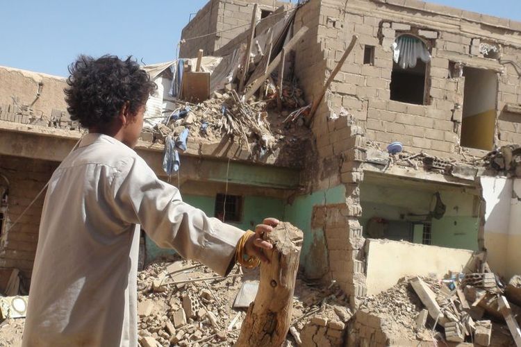 Seorang anak memperhatikan reruntuhan akibat serangan. Pada 2017, tercatat ada 1.316 anak yang terbunuh maupun cacat karena konflik di Yaman.