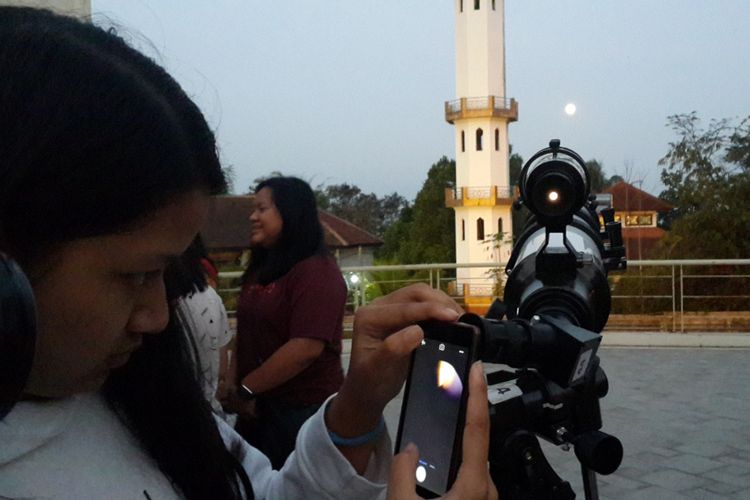 Salah satu peserta saat melihat posisi Bulan sebelum proses Gerhana Bulan Total (GBT) terjadi di Universitas Ma Chung, Kota Malang, Jumat (27/7/2018)