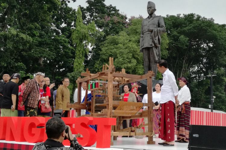 Presiden Joko Widodo mencoba menenun kain sarung dengan alat tenun bukan mesin (ATBM) di Festival Sarung Indonesia 2018, Plaza Tenggara, Gelora Bung Karno, Jakarta, Minggu (3/3/2019).