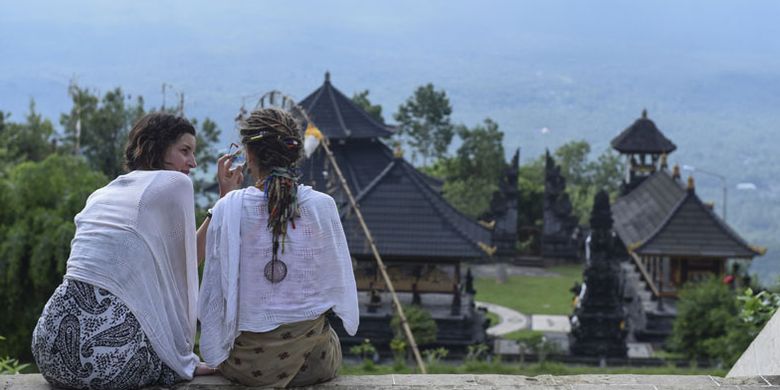 Wisatawan asing berada di Pura Lempuyang, Karangasem, Bali, Kamis (7/12/2017). Menteri Pariwisata Arief Yahya menyatakan pemerintah memangkas target kunjungan wisatawan mancanegara pada tahun ini dari 15 juta menjadi 14 juta wisatawan akibat erupsi Gunung Agung di Bali.