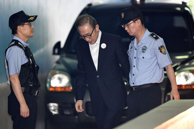 Mantan presiden Korea Selatan Lee Myung-bak dikawal petugas saat menghadiri persidangan di Seoul, pada 6 September 2018.