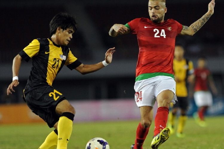 Bek timnas Indonesia, Diego Michiels, mencoba menghentikan pergerakan pemain Malaysia pada laga semifinal SEA Games 2013 di Myanmar, 19 Desember 2013. 
