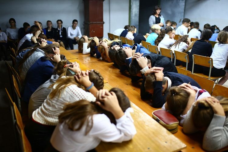 Para siswa Sekolah Nomor 8 di desa Sartana, Ukraina melakukan latihan bagaimana melindungi diri saat terjadi serangan bom.
