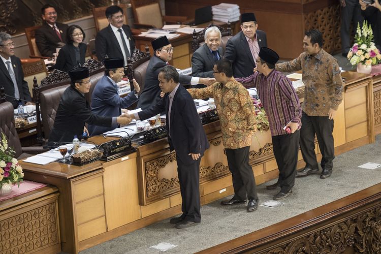 Anggota Fraksi PKS Al Muzammil Yusuf (kedua kanan), Sekretaris Fraksi PAN Yandri Susanto (ketiga kanan), Wakil Ketua F-Demokrat Benny K Harman (keempat kanan) dan Ketua Fraksi Gerindra Ahmad Muzani (kanan) berjabat tangan dengan lima pimpinan DPR untuk meninggalkan ruang sidang (walk out) sebelum pengambilan keputusan pengesahan RUU Pemilu pada sidang Paripurna DPR ke-32 masa persidangan V tahun sidang 2016-2017 di Kompleks Parlemen Senayan, Jakarta, Jumat (21/7/2017) dini hari. DPR mengesahkan RUU Pemilu menjadi undang-undang setelah melalui mekanisme dan memilih opsi A, yaitu Presidential Threshold sebesar 20 persen kursi DPR atau 25 persen suara nasional. 