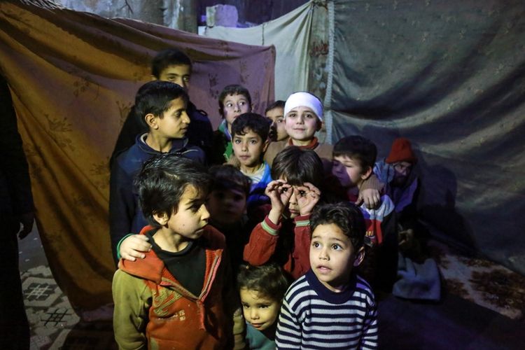Anak-anak Suriah berlindung di ruang bawah tanah yang digunakan untuk menghindari serangan bom di kota Douma, di Ghouta Timur.