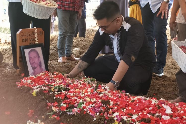 Michael Wowor menangis di depan pusara ayahnya, Rudy Wowor, di TPU Pondok Ranggon, Jakarta Timur, Sabtu (6/10/2018).