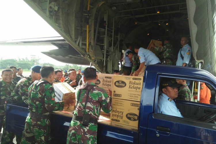 Anggota TNI AU memasukkan bantuan logistik bahan makanan dan pakaian ke pesawat Hercules yang akan terbang ke Asmat, Papua, di Lanud Iswahjudi, Kabupaten Magetan, Jawa Timur, Selasa (29/1/2018).
