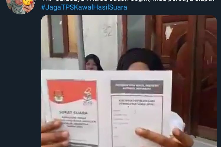 Seorang wanita menunjukkan surat suara yang sudah lebih dulu tercoblos di salah satu TPS di Surabaya.