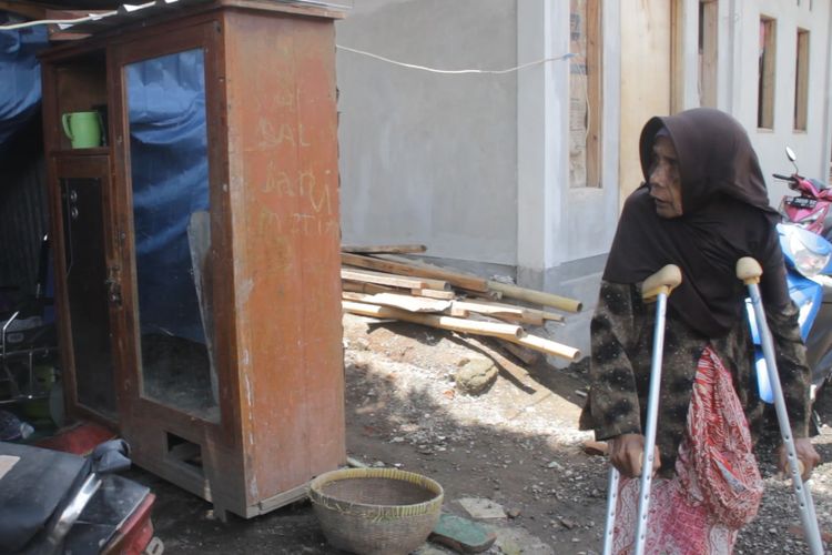 Inaq Suri (85) masih mengungsi di bawah pohon mangga dengan terpal biru seadanya. Dia dikepung rumah rumah tahan gempa bantuan pemerintah di Pengempel, Bertais, Kecamatan Sandubaya, Kota Mataram.