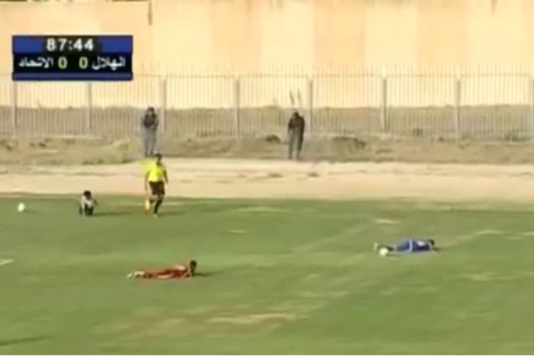 Para pemain kesebelasan Al-Ittihad dan Al-Hilal yang berlaga dalam babak final Piala Libya merebahkan badan mereka ke lapangan saat suara tembakan terdengar di sekitar stadion.