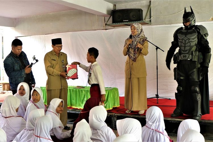 Abdul Gafur, Kepala MTsN 1 Balikpapan memegang wadah koinku untuk buku menerima sumbangan koin dari siswa baru di madrasah tersebut.