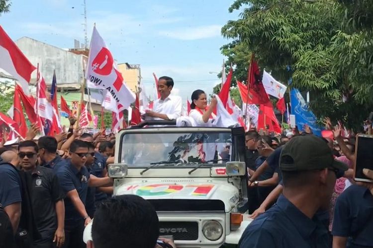 Calon presiden nomor urut 01 Joko Widodo dan sang istri Iriana menaiki mobil jip putih saat menghadiri kampanye terbuka di GOR Satria, Kecamatan Purwokerto, Kabupaten Banyumas, Kamis (4/4/2019).