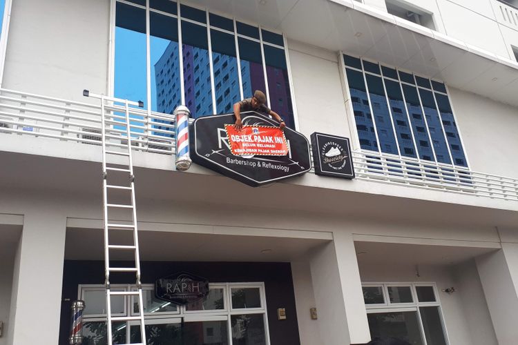 Unit Pelayanan Pajak dan Retribusi Daerah (UPPRD) Cempaka Putih memasang stiker tunggakan dan utang pajak daerah di 30 tempat di kawasan Cempaka Putih, Jakarta Pusat, salah satunya Green Pramuka Square pada Rabu (7/11/2018). Ada 10 tenant di Green Pramuka Square yang belum membayar pajak papan reklame diantaranya Mokka Coffe Cabana, Raa Cha, dan Rapih Barbershop.