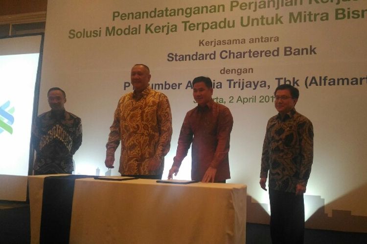 CEO Standard Chartered Indonesia Rino Donosepoetro dan CEO Alfamart Hans Prawira menandatangani kerja sama modal solusi kerja terpadu di Hotel Shangri-La Jakarta, Senin (2/4/2018).