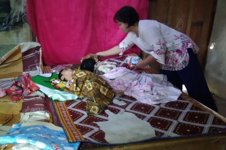 Sumini (39) merawat kedua anaknya yang terkena penyakit hidrosefalus yakni Ahmad Yuandi Nurrova (10), dan Riza Gionino (6) di rumahnya di Dusun Rejosari, Desa Terong, Kecamatan Dlingo, Kabupaten Bantul, Yogyakarta, Kamis (23/8/2018)