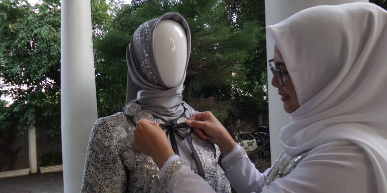 Desainer Nina Septiana ketika mengikat pita pada salah satu koleksi busana yang akan dibawa ke ajang Hong Kong Fashion Week Fall/Winter 2019. (KOMPAS.com/Nabilla Tashandra)