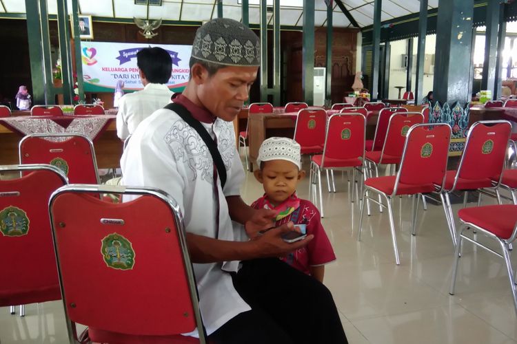 Luqman Nurhidayat (5), dan ayahnya Tumiyo (43) saat Keluarga Penyintas Kanker Gunungkidul (KPKG) yang sedang bersilaturahmi di Bangsal Sewokoprojo, Wonosari, Minggu (1/7/2018)