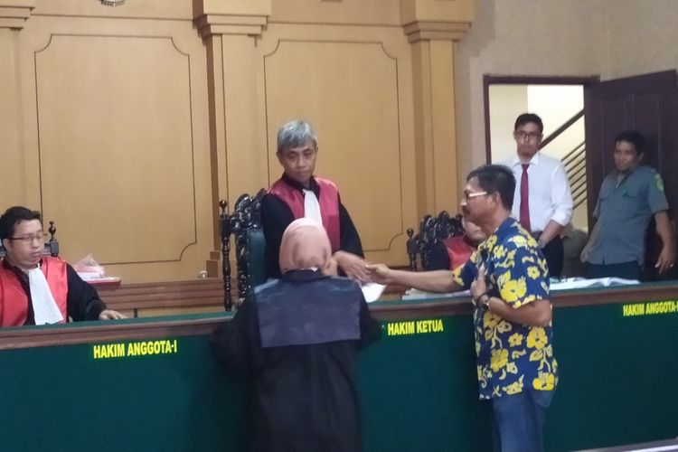 Jumali (baju batik) terdakwa perkara kekerasan terhadap mantan jurnalis Radar Madura,Ghinan Salman, bersalaman dengan ketua majelis hakim setelah divonis bebas, Senin (29/4/2019).