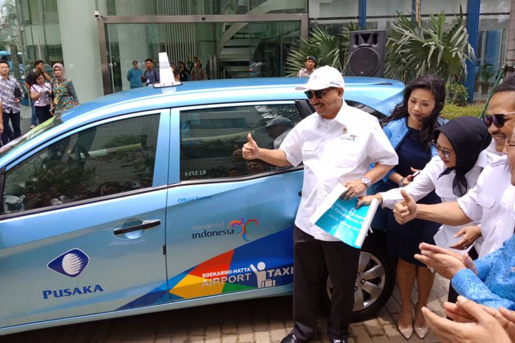 Menteri Pariwisata, Arief Yahya menempelkan stiker logo Wonderfull Indonesia di salahs atu taxi Blue Bird usai penandatanganan kerjasama antar keduanya di kantor Blue Bird, Mampang, Jakarta, (26/3/2017).