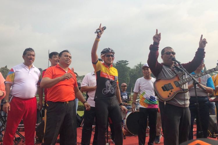 Wakil Gubernur DKI Jakarta Sandiaga Uno bernyanyi dengan band Gus Ploes di kawasan Monas, Jumat (23/3/2018). 